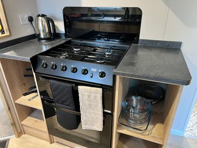 A kitchen with an oven and kettle at Hafan y Mor - 159 Snowdonia in Pwllheli