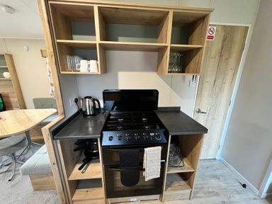 A kitchen unit with stove and kettle at Hafan y Mor - 159 Snowdonia Pwllheli
