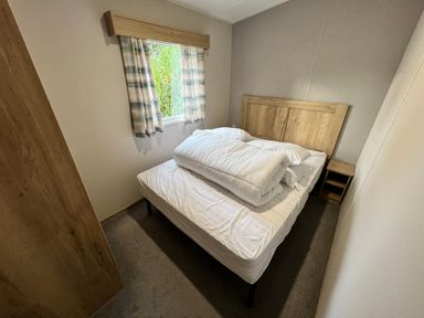 A bedroom with a bed and window at Hafan y Mor - 159 Snowdonia Pwllheli