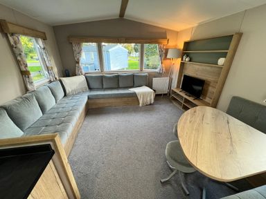 A living room with a sofa and a table at Hafan y Mor - 159 Snowdonia Pwllheli