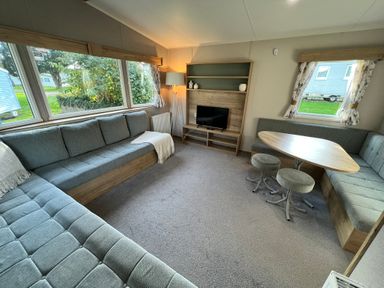 A living room with a sofa and table at Hafan y Mor - 159 Snowdonia Pwllheli