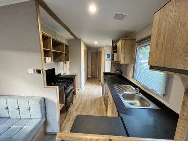 A kitchen with a stove and sink at Hafan y Mor - 159 Snowdonia in Pwllheli