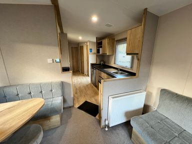 A kitchen with table and cabinets at Hafan y Mor - 159 Snowdonia Pwllheli