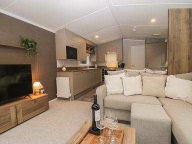 A living room with a sofa and coffee table at Lake It Easy in Troutbeck Bridge
