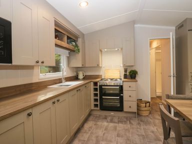 A kitchen with cabinets and an oven at Lake It Easy Troutbeck Bridge