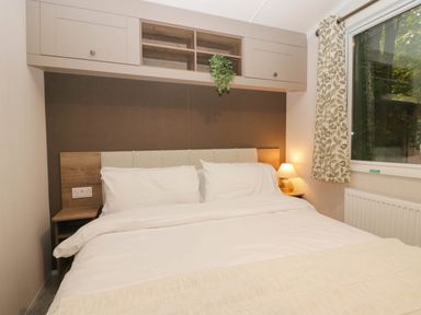 A bedroom with a bed and shelf at Lake It Easy Troutbeck Bridge