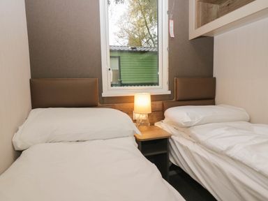 A bedroom with two beds and a lamp at Lake It Easy in Troutbeck Bridge