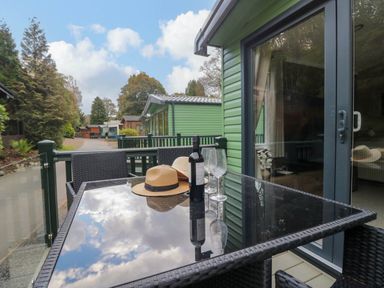 An outdoor dining area with a table and chairs at Lake It Easy Troutbeck Bridge