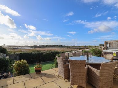 A garden with a table and chairs overlooking a field at Bay View in Weymouth