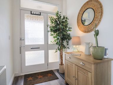 A hallway with a console table and plants at Bay View in Weymouth