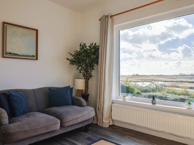 A living room with a sofa and a large window at Bay View in Weymouth
