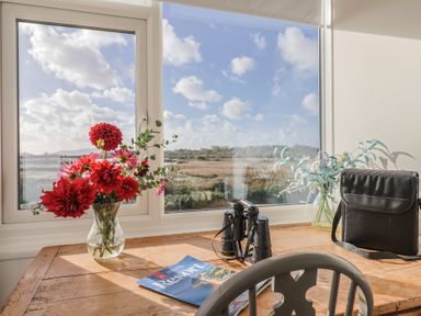 A table with flowers and binoculars at Bay View in Weymouth