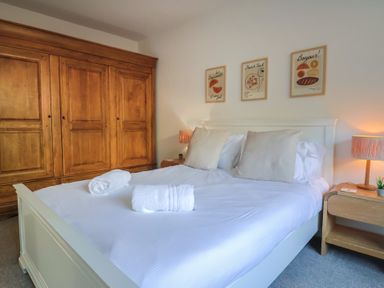 A bedroom featuring a bed and wooden wardrobe at Bay View in Weymouth