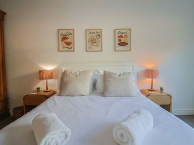 A bedroom with bed and wall art at Bay View in Weymouth
