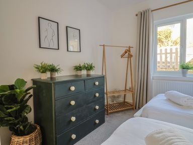 A bedroom with two beds and a dresser at Bay View in Weymouth