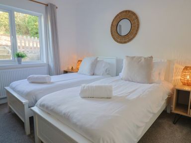 A bedroom with twin beds and a window at Bay View in Weymouth