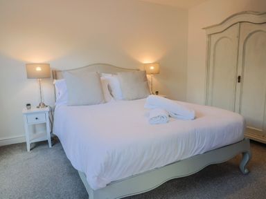 A bedroom with a bed, lamps, and a wardrobe at Bay View in Weymouth