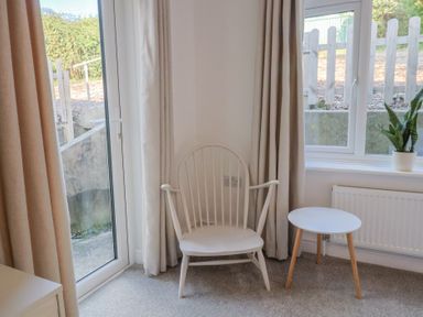 A sitting room with a chair and table at Bay View in Weymouth