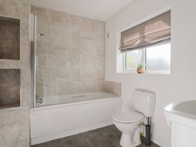 A bathroom with a bathtub and toilet at Bay View in Weymouth