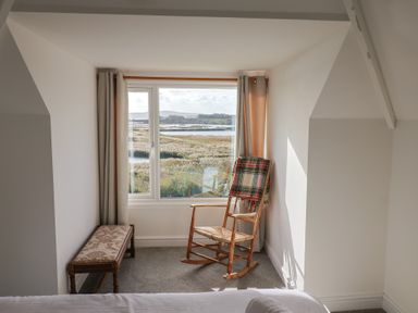 A bedroom with a window and chair at Bay View in Weymouth