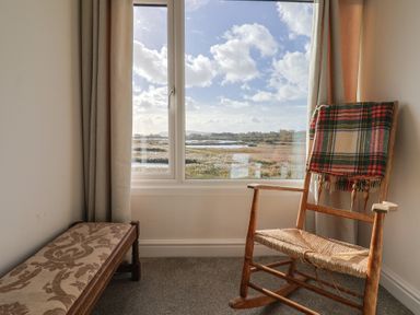 A living room with a rocking chair and a view out the window at Bay View in Weymouth