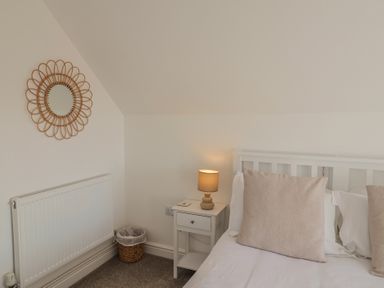 A bedroom with a bed and a lamp at Bay View in Weymouth