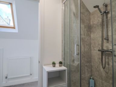 A bathroom with shower and shelf at Bay View in Weymouth