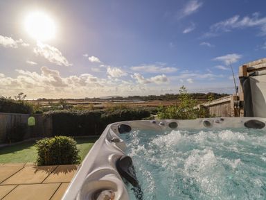 A hot tub with a view of the sky and garden at Bay View in Weymouth