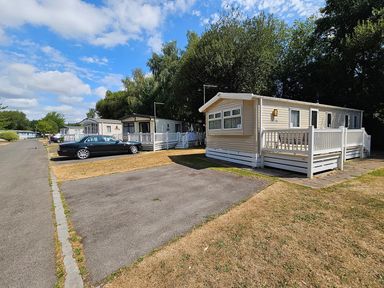 An outdoor area with mobile homes and a parked car