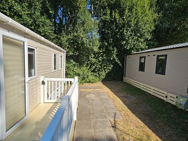An outdoor area with two mobile homes and a pathway between them