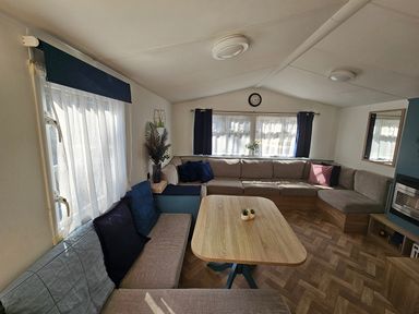 A living room with a large sofa and table at the property
