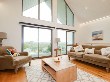 A living room with a sofa and armchair at 1 Endellion View Wadebridge