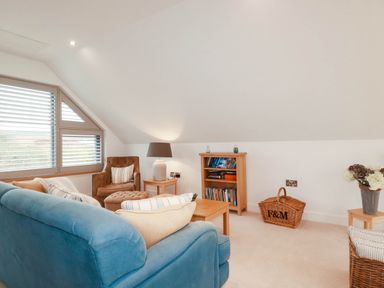 A living room with a sofa and bookshelves at 1 Endellion View Wadebridge