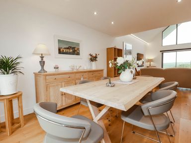 A dining room with a table and chairs at 1 Endellion View in Wadebridge