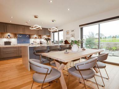 A kitchen with dining area and large windows at 1 Endellion View Wadebridge