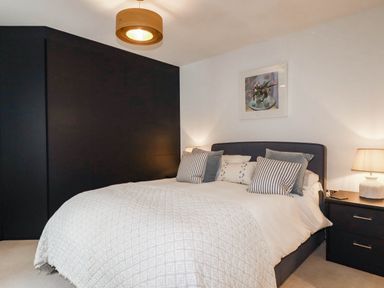 A bedroom with a bed and nightstands at 1 Endellion View Wadebridge