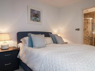 A bedroom with a bed and bedside table at 1 Endellion View Wadebridge