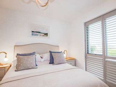 A bedroom with a bed and lamp at 1 Endellion View Wadebridge