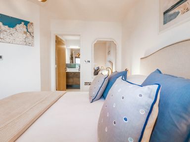 A bedroom with a bed and cushions at 1 Endellion View Wadebridge