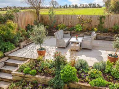 A garden with seating area and flower pots at 1 Endellion View Wadebridge