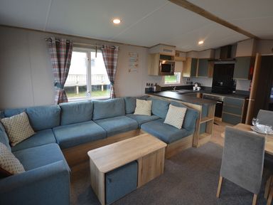 A living room with a sofa and coffee table at Perran Sands Holiday Park - 615 Chy-an-Mor in Perranporth