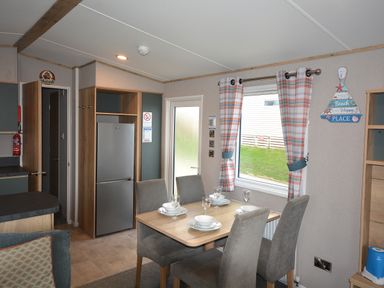 A dining area with a table and chairs at Perran Sands Holiday Park - 615 Chy-an-Mor, Perranporth
