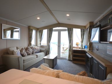 A living room with a sofa and television at Perran Sands Holiday Park - 620 Chy An Mor Perranporth