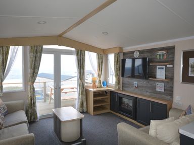 A living room with a television and sofa at Perran Sands Holiday Park - 620 Chy An Mor Perranporth