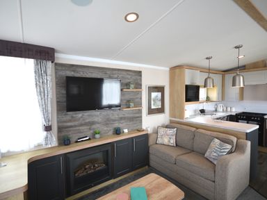 A living room with a television and sofa at Perran Sands Holiday Park - 620 Chy An Mor, Perranporth