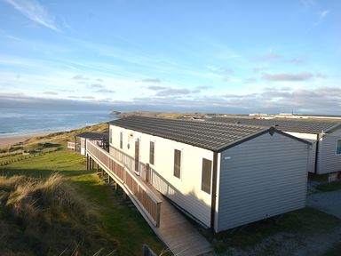 A caravan with decking overlooking the sea at Perran Sands Holiday Park - 621 Chy-an-Mor Perranporth