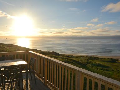 A deck with a table and chairs overlooking the ocean at Perran Sands Holiday Park - 621 Chy-an-Mor Perranporth