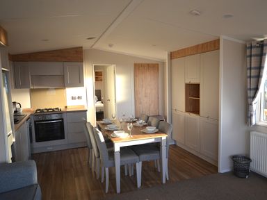 A kitchen with table and chairs at Perran Sands Holiday Park - 621 Chy-an-Mor Perranporth