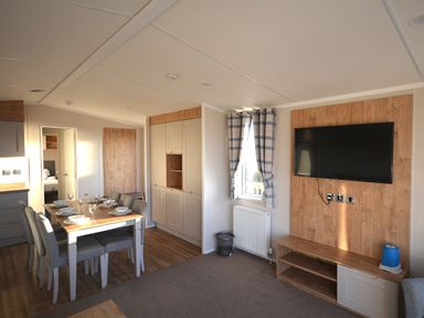 A living room with a table and chairs at Perran Sands Holiday Park - 621 Chy-an-Mor, Perranporth