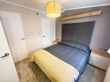 A bedroom with a bed and bedside table at Perran Sands Holiday Park - 621 Chy-an-Mor, Perranporth